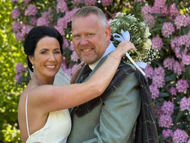 Wedding couple smiling at camera by Let's Do It Creative